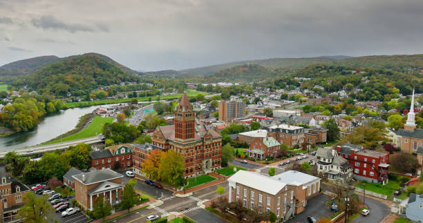 Aerial shot of Cumberland, a small city in Allegany County, Maryland surrounded by a mountainous forest landscape, on an overcast day in Fall.