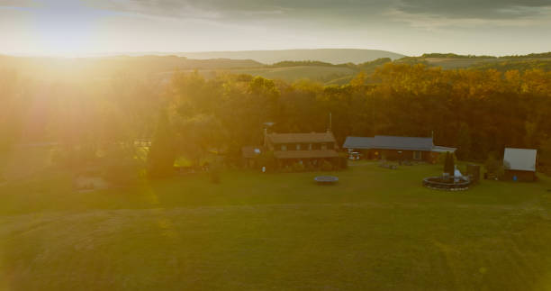 Drone shot of a house set on a farm in the rolling countryside of Lycoming County, Pennsylvania on a Fall sunset.