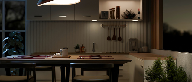 A dining table in a contemporary kitchen with kitchen appliances and decor at night. 3d render, 3d illustration