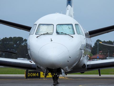 A Rex Airlines Saab 340B+ plane, registration VH-ZRJ, parked behind the domestic terminal of Sydney Kingsford-Smith Airport. This image was behind the steel security fence at Gate 8 in Eleventh Street, Mascot on an overcast afternoon on 2 March 2024.