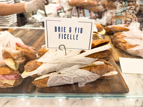 Delicious baguette sandwiches with brie cheese and fig jam in a bakery retail display