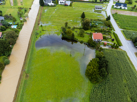Aerial view of a flooded rural area with submerged fields, houses, and roads after heavy rainfall.