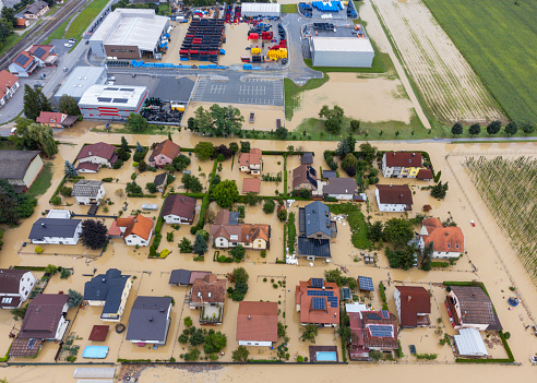Aerial view of a flooded residential area with submerged streets and houses, showcasing the impact of natural disasters on a community. Location: Zalec, Slovenia