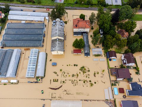 Aerial view of a flooded residential area with submerged streets and houses, showcasing the impact of natural disasters on communities. Location: Zalec, Slovenia