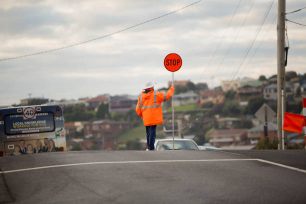 Burnie, Tasmania, Australia, June16, 2016: View of a school road crossing guard holding a stop sign to allow school children to safely cross the road