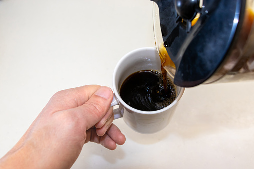 Coffee pouring into a cup from a coffee server