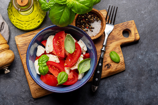 Caprese salad with ripe tomatoes, mozzarella cheese and garden basil. Flat lay