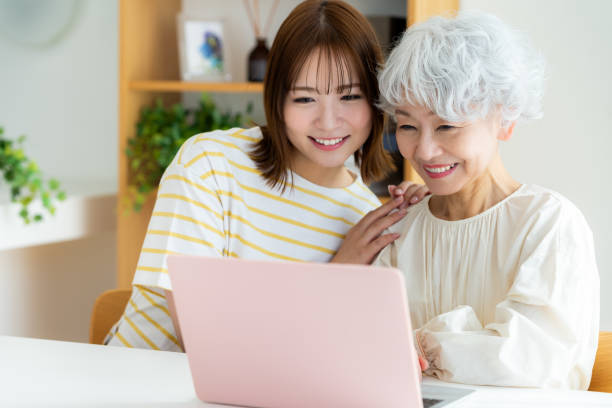 istock Senior woman learning how to use a computer in the living room 2064955274