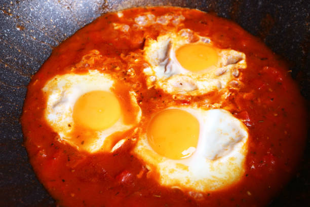 istock Shakshuka, poached eggs in flavorful tomato sauce during cooked in a cast iron pan 2064969071