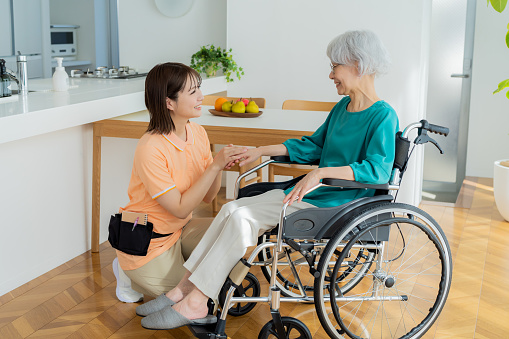 Caregiver supporting a woman in a wheelchair