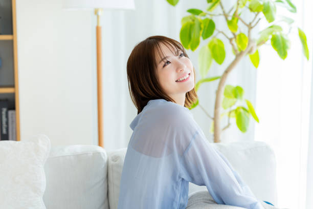 young woman relaxing on the sofa - リフレッシュ ストックフォトと画像