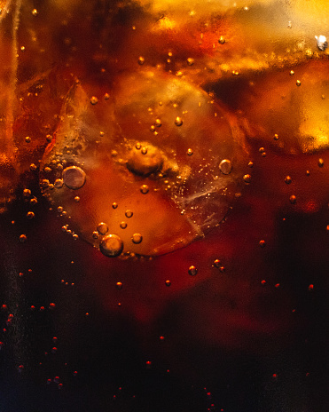 A close-up of a refreshing glass of juice with ice and bubbles