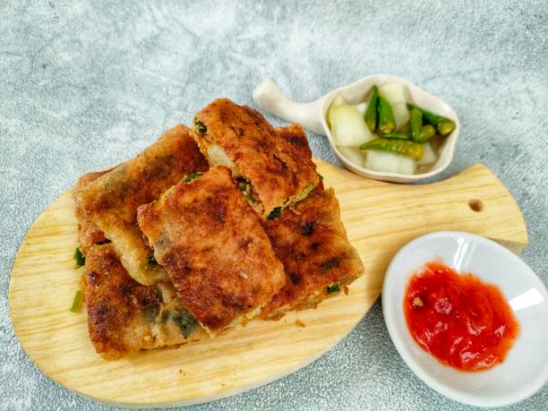istock Egg martabak is a traditional Indonesian food which is placed on a plate with vegetables, meat and various other spices wrapped in dough which is flattened thinly and then fried, selective focus. 2065075665