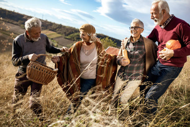 istock Happy mature couples going on a picnic in autumn day. 2065076748