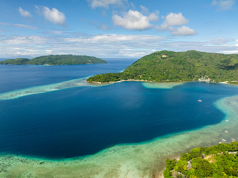 Drone view of Island with turquoise water at coast and blue sea. Gargantos Beach Resort. Romblon, Philippines.