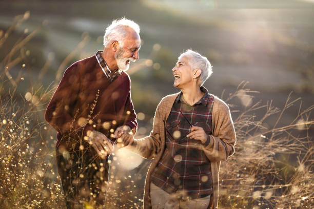 istock Cheerful mature couple talking while walking through tall grass in nature. 2065079960