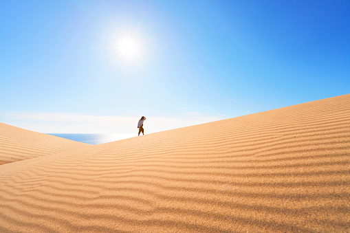 Walking young woman at sunny day at Patara sand dunes