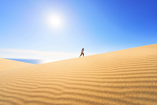 Walking young woman at sunny day at Patara sand dunes