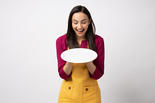 Portrait of young woman chef wearing yellow apron isolated white color background