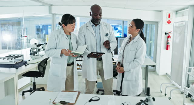 Tablet, teamwork or scientists talking in laboratory for chemistry research report or test feedback. Medical data, people or science update on website or search for online medicine development news