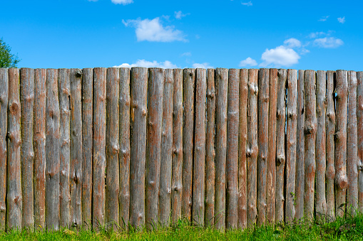 Log wooden fence. The texture of the old wooden fence. Wooden vintage background.