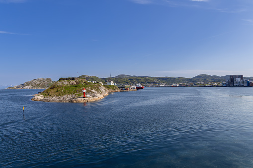Bodo - Norway. June 17, 2023: A scenic summer view from the Bodo-Moskenes ferry in Norway captures the bustling port of Bodo, set against a backdrop of mountains and a clear blue sky