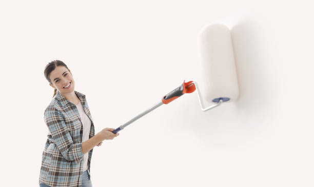 istock Happy woman painting walls with a roller 2065149748