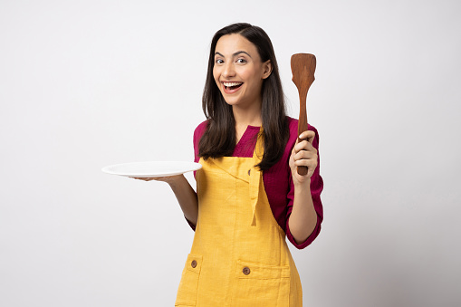 Portrait of young woman chef wearing yellow apron isolated white color background