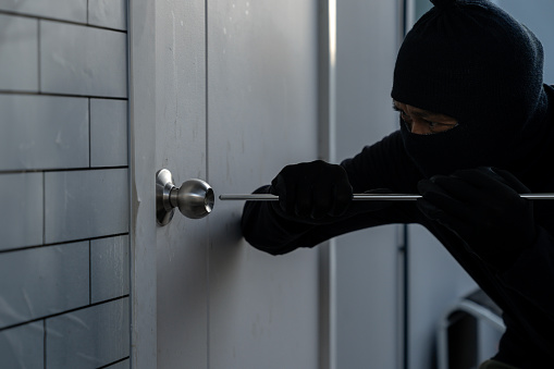 Burglar attempting to break into a house