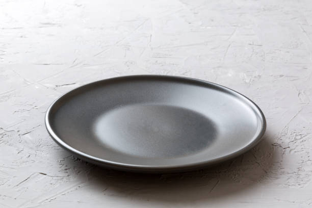 istock Perspective view of empty black plate on cement background. Empty space for your design 2065176763