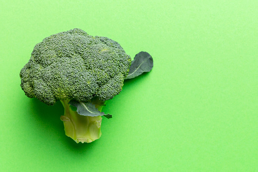 Top view fresh green broccoli vegetable on Colored background. Broccoli cabbage head Healthy or vegetarian food concept. Flat lay. Copy space.