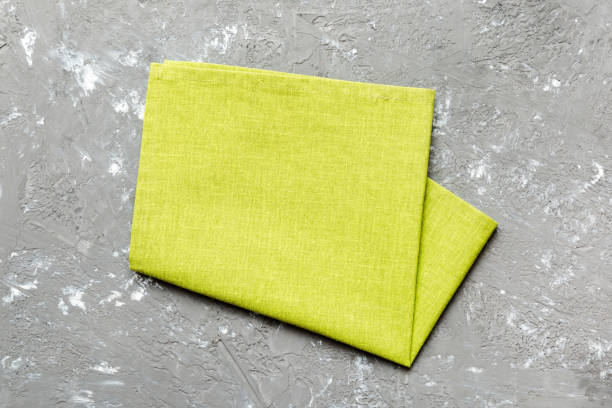 istock top view with green kitchen napkin isolated on table background. Folded cloth for mockup with copy space, Flat lay. Minimal style 2065177854