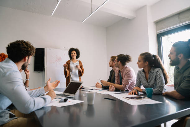 istock Smiling diverse colleagues gather in boardroom brainstorm discuss financial statistics together 2065183160