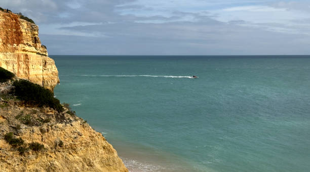 istock Fragile cliffs and a tour boat in the distance 2065205458