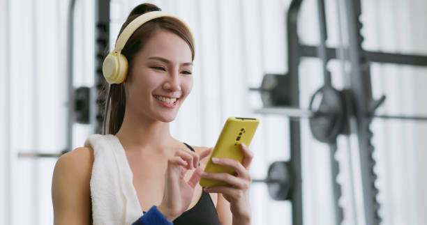 istock female smartphone headset at gym 2065243022