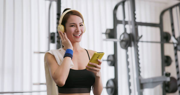 istock female smartphone headset at gym 2065243050