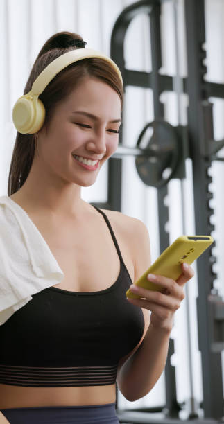 istock female smartphone headset at gym 2065243573