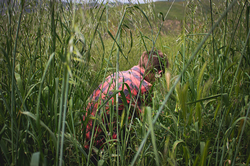 A person standing in grass, searching intently