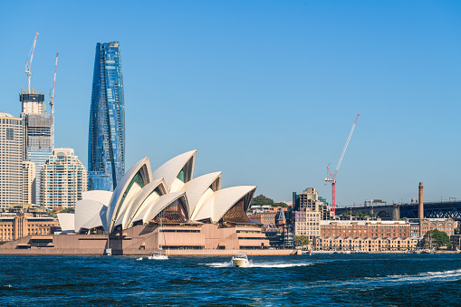Sydney, Australia - April 17, 2022: Sydney Opera House with Crown Towers Sydney viewed from ferry towards the city on a bright sunny day