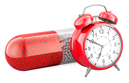 Time to take medicine, concept. Medicament Capsule with alarm clock, 3D rendering isolated on white background