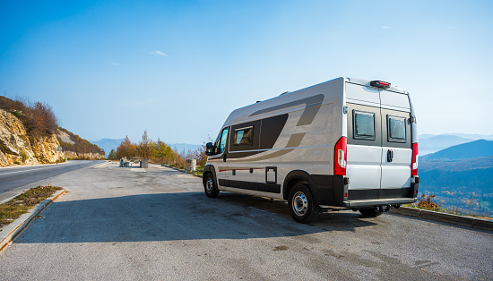 Campervan, Motorhome RV parked on the side of the road in Bosnia and Herzegovina. Travelers with camper van or motor home are resting on an active family vacation on a road trip in Balkans.