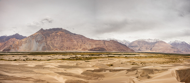 Panorama of the Sand dunes of Nubra Valley surrounded by mountain peaks of the greater Himalayas