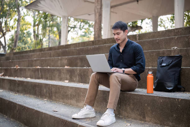 istock A young Asian businessman rides a bicycle to work. Use a reusable water bottle. Working outside of the office using a laptop The concept of saving energy and reducing pollution to the environment. 2065307865