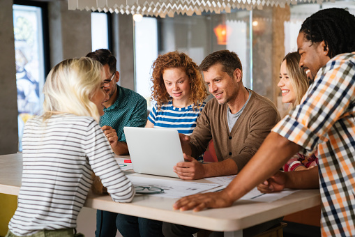 Startup young business team on meeting in modern bright office interior and working together