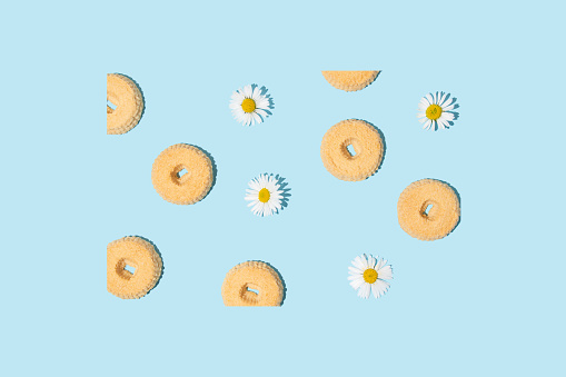 Cookies with white daises on a blue background. Abstract concept.