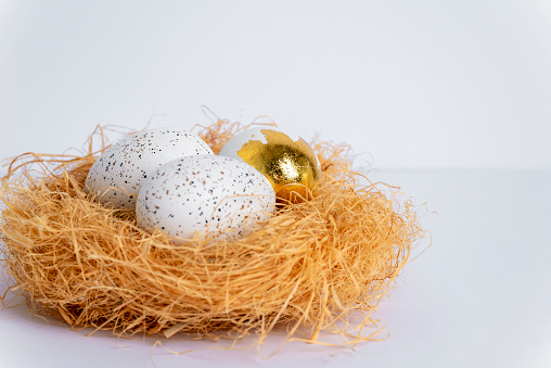 Nest with Easter eggs on white table. Selective focus.