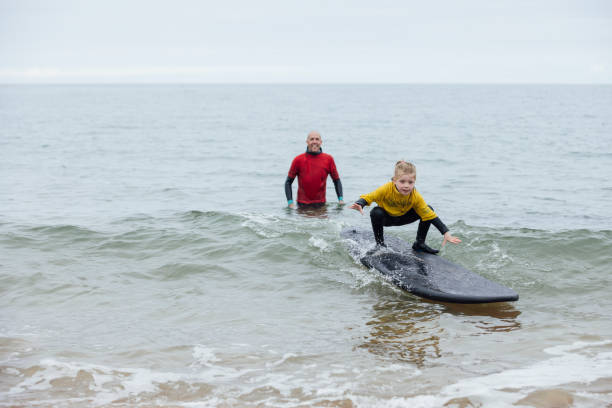 learning to surf - surfing role model learning child fotografías e imágenes de stock