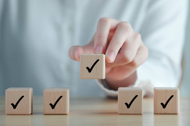 istock Hand holding check mark on wooden blocks. 2065347977