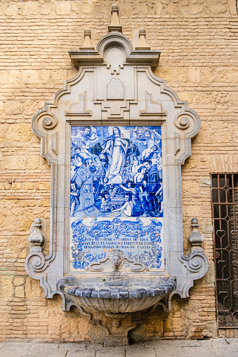 Ceramic tilework depicting the Virgin Mary on a Baroque fountain leaning against the wall of the 13th-century Church of San Francisco in the old town of Cordoba