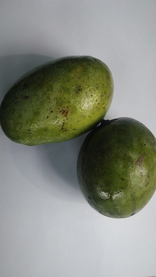 Kuini fruit (Mangifera odorata) on a white background